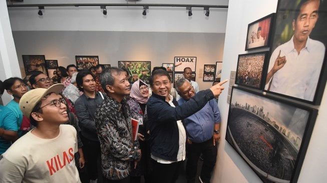 Menkominfo Rudiantara (kedua kanan), Ketua KPU Arief Budiman (kanan), dan Dirut LKBN Antara Meidyatama Suryodiningrat (kedua kiri) melihat foto-foto yang ditampilakan pada pameran foto dan peluncuran buku Kilas Balik 2018 di Galeri Foto Jurnalistik Antara, Jakarta, Jum'at (26/4/2019). [Antara/Indrianto Eko Suwarso]