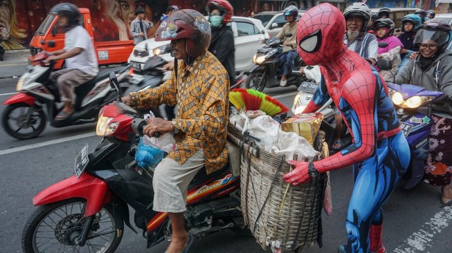 Warga mengenakan kostum superhero Spiderman membagikan takjil kepada pengguna jalan saat kegiatan Bagi-Bagi Takjil Komunitas Cosplay di jalan Gatot Subroto, Solo, Jawa Tengah, Minggu (19/5). [ANTARA FOTO/Mohammad Ayudha]