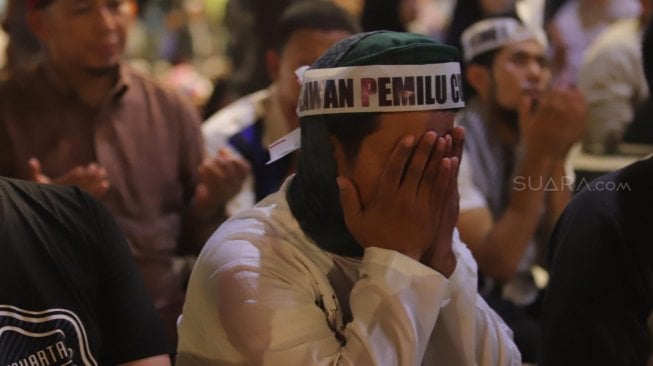 Massa Gerakan Nasional Kedaulatan Rakyat menunaikan shalat Tarawih di sela aksi unjuk rasa di depan Kantor Bawaslu Jakarta, Selasa (21/5). [Suara.com/Muhaimin A Untung]