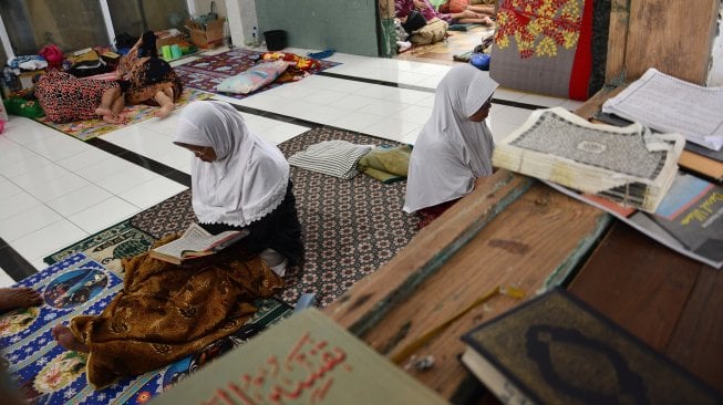 Santri lansia membaca Alquran di Pondok Pesantren Darul Ulum, Rejoso, Peterongan, Jombang, Jawa Timur, Selasa (21/5).  [ANTARA FOTO/Syaiful Ari]