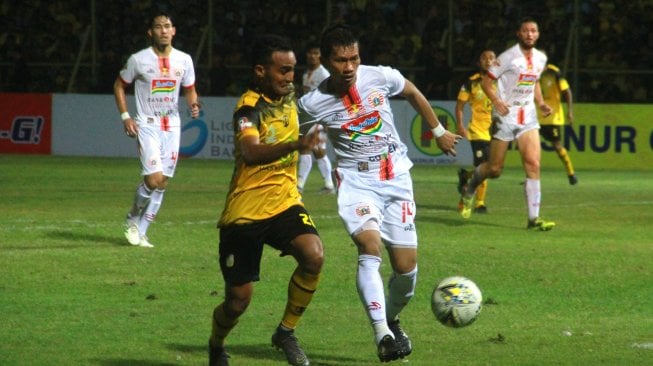 Pesepak bola Barito Putera Rizky Rizaldi Pora (kiri) berebut bola dengan pesepak bola Persija Jakarta Ismed Sofyan (kanan) saat pertandingan Liga 1 2019 di Stadion 17 Mei Banjarmasin, Kalimantan Selatan, Senin (20/5/2019). Pertandingan tersebut berakhir dengan skor imbang 1-1. ANTARA FOTO/Bayu Pratama S/wsj.