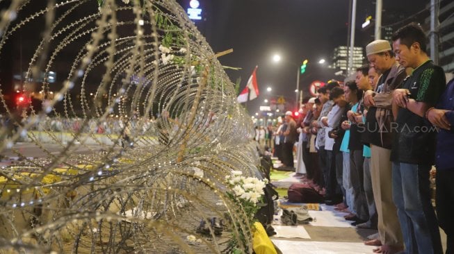 Massa Gerakan Nasional Kedaulatan Rakyat menunaikan shalat Tarawih di sela aksi unjuk rasa di depan Kantor Bawaslu Jakarta, Selasa (21/5). [Suara.com/Muhaimin A Untung]