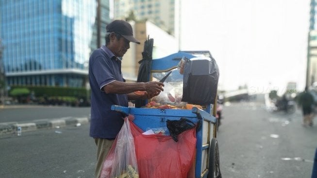 Sukadi tetap berdagang rujak di tengah-tengah kondisi Jakarta pasca kerusuhan. (Suara.com/Yasir).