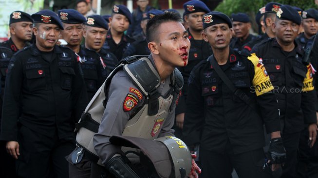 Sejumlah personel kepolisian mengalami luka dan pingsan usai bentrok dengan massa di Slipi, Jakarta, Rabu (22/5). [Suara.com/Arief Hermawan P]