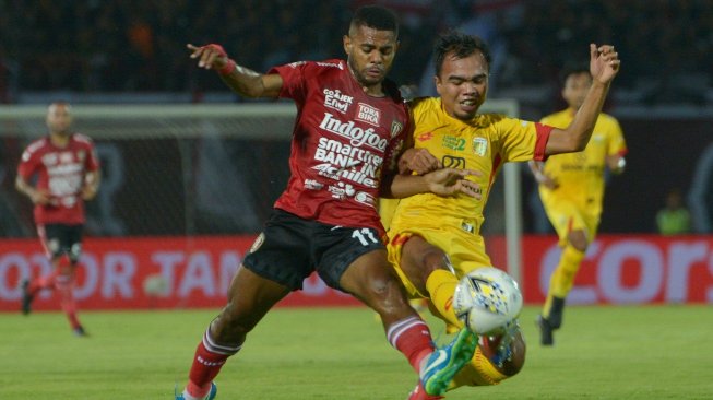 Pemain Bhayangkara FC, Muhammad Fatchu Rochman (kanan) berebut bola dengan penyerang Bali United, Yabes Roni, dalam pekan kedua Liga 1 2019 di Stadion I Wayan Dipta, Gianyar, Selasa (21/5/2019). [Antara/Nyoman Budhiana]