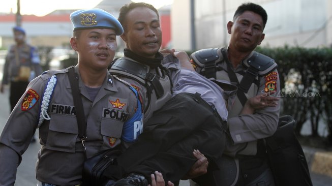 Sejumlah personel kepolisian mengalami luka dan pingsan usai bentrok dengan massa di Slipi, Jakarta, Rabu (22/5). [Suara.com/Arief Hermawan P]