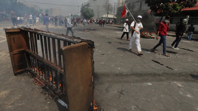 Bentrok antara polisi dan massa aksi di Jalan Jati Baru, Tanah Abang, Jakarta, Rabu (22/5). [Suara.com/Muhaimin A Untung]