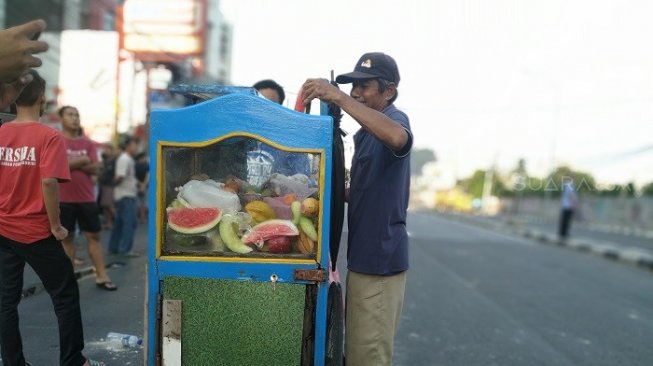 Sukadi tetap berdagang rujak di tengah-tengah kondisi Jakarta pasca kerusuhan. (Suara.com/Yasir).