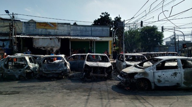 Bangkai mobil di kompleks Asrama Brimob Petamburan yang dibakar massa. (Suara.com/M Yasir)