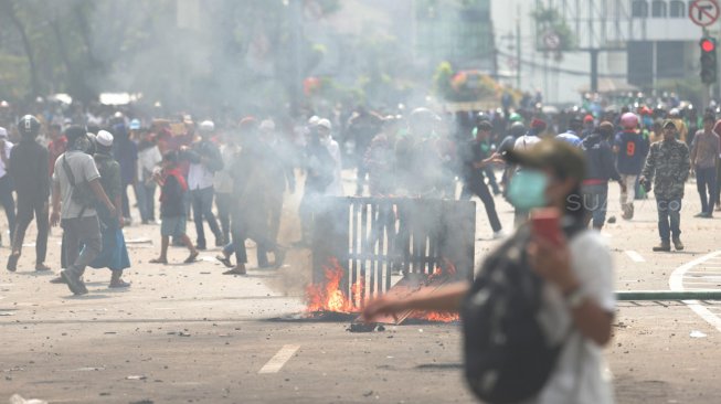 Bentrok antara polisi dan massa aksi di Jalan Jati Baru, Tanah Abang, Jakarta, Rabu (22/5). [Suara.com/Muhaimin A Untung]