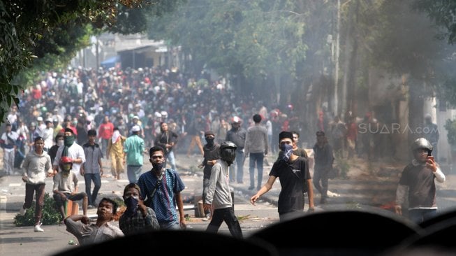 Bentrok antara massa dan pihak kepolisian di Jalan Slipi 1, Jakarta, Rabu (22/5). [Suara.com/Arief Hermawan P]
