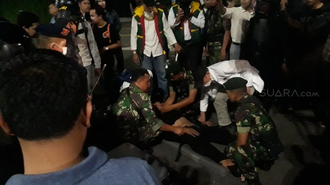 Anggota brimob pingsan dalam bentrokan di Bawaslu. (Suara.com/Novian).