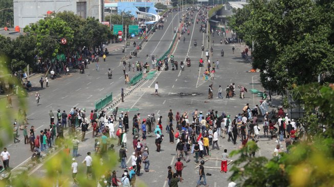 Bentrok antara polisi dan massa aksi di Jalan Jati Baru, Tanah Abang, Jakarta, Rabu (22/5). [Suara.com/Muhaimin A Untung]