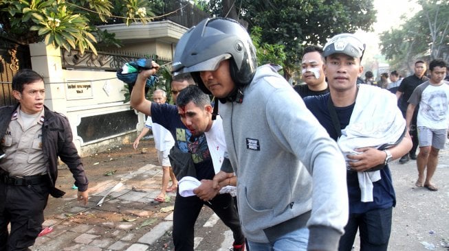 Polisi dan warga menangkap seorang yang diduga provokator pembakaran mobil di Komplek Asrama Brimob, Petamburan, Jakarta, Rabu (22/5). [Suara.com/Arief Hermawan P]