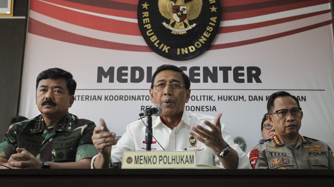 Menkopolhukam Wiranto (tengah) bersama Panglima TNI Marsekal TNI Hadi Tjahjanto (kiri) dan Kapolri Jenderal Pol Tito Karnavian (kanan) menyampaikan perkembangan demonstrasi anarkis di Jakarta di Jakarta, Rabu (22/5/2019). [Antara/Dhemas Reviyanto]