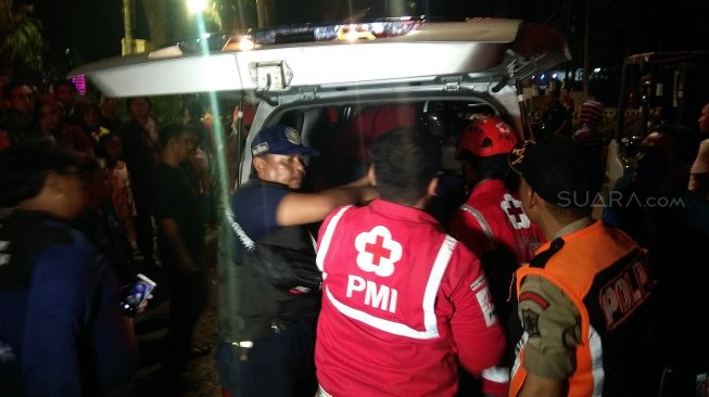 Tim gabungan mengevakuasi jenazah satu pekerja proyek berinisial M (40) ke mobil ambulans. Korban tewas tertimpa beton saat mengerjakan gorong-gorong di Taman Bungkul, Surabaya, Jawa Timur, Sabtu (25/5/2019) malam. [Suara.com/Dimas Angga Perkasa]