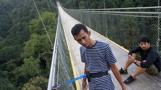 Wisatawan Jembatan Gantung Situ Gunung (Suspension Bridge Situ Gunung) di Kawasan Taman Nasioal Gunung Gede Pangrango (TNGGP), Kadudampit, Kabupaten Sukabumi, Jawa Barat, Jumat (25/5). [Suara.com/Arief Hermawan P]