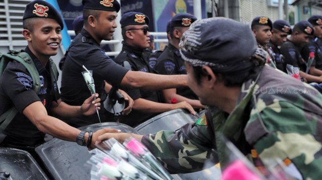 Sejumlah anggota komunitas Spartan Nusantara memberi bunga ke petugas kepolisian saat aksi dukungan di depan kantor Bawaslu, Jakarta, Minggu (26/5). [Suara.com/Muhaimin A Untung]