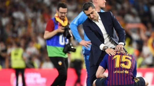 Pelatih Barcelona Ernesto Valverde mencoba menenangkan bek Clement Lenglet setelah skuatnya dikalahkan Valencia di final Copa del Rey di Benito Villamarin, Sevilla. JOSE JORDAN / AFP