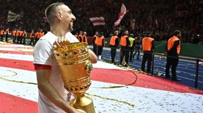 Gelandang Bayern Munich Franck Ribery mengangkat trofi Piala Jerman atau DFB Pokal setelah di final mengalahkan RB Leipzig di Olympic Stadium. John MACDOUGALL / AFP