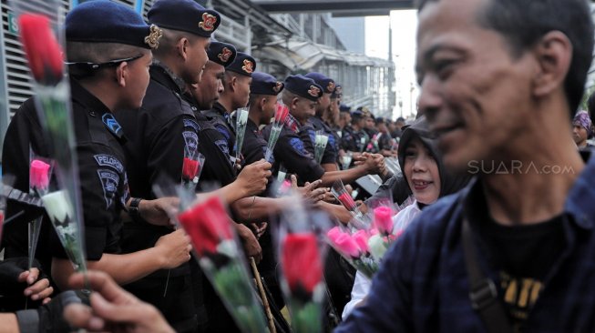 Sejumlah anggota komunitas Spartan Nusantara memberi bunga ke petugas kepolisian saat aksi dukungan di depan kantor Bawaslu, Jakarta, Minggu (26/5). [Suara.com/Muhaimin A Untung]