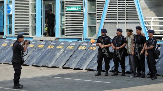 Warga berfoto dengan petugas polisi di Gedung Badan Pengawas Pemilu (Bawaslu) saat Hari Bebas Kendaraan Bermotor di kawasan Sarinah, Jakarta, Minggu (26/5). [Suara.com/Muhaimin A Untung]