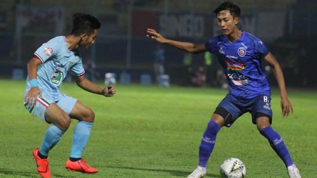 Pesepakbola Arema FC, Johan Ahmad Alfarisy (kanan) berusaha melewati hadangan pesepakbola Persela Lamongan, Muhammad Hambali (kiri) dalam pertandingan Liga 1 di Stadion Kanjuruhan, Malang, Jawa Timur, Senin (27/5/2019). Di akhir babak pertama, Arema FC sementara unggul dengan skor 3-2. ANTARA FOTO/Ari Bowo Sucipto