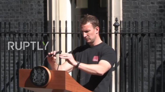 Teknisi Ganteng Ini Viral saat Pengumuman PM Inggris Theresa May Mundur. (YouTube/Ruptly)