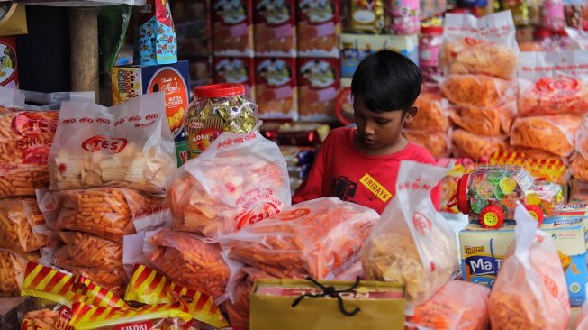 Sejumlah calon pembeli memilih kue kering dalam kemasan di lapak penjual kue musiman di depan pabrik Khong Guan, Jalan Raya Bogor Km. 26, Ciracas, Jakarta Timur, Senin (27/5). [Suara.com/Muhaimin A Untung]