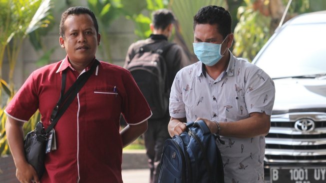 Kepala Kantor Imigrasi Kelas I Mataram - Nusa Tenggara Barat (NTB) Kurniadi (kanan) menutupi mukanya dengan masker saat tiba di gedung KPK, Jakarta, Selasa (28/5/2019). [Antara/Reno Esnir]