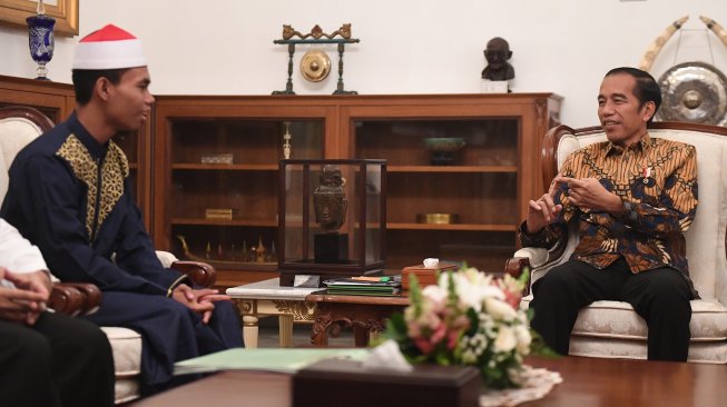 Presiden Joko Widodo berbincang dengan pemenang Musabaqah Tilawatil Quran (MTQ) Internasional Ke-7 di Turki, Syamsuri Firdaus (kiri) dalam pertemuan di Istana Merdeka, Jakarta, Selasa (28/5).  [ANTARA FOTO/Akbar Nugroho Gumay]
