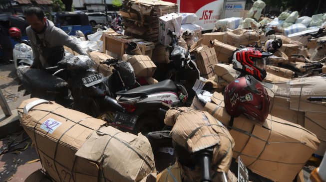 Pekerja merapikan sepeda motor yang akan dikirim di Stasiun Pasar Senen, Jakarta, Rabu (29/5). [Suara.com/Muhaimin A Untung]
