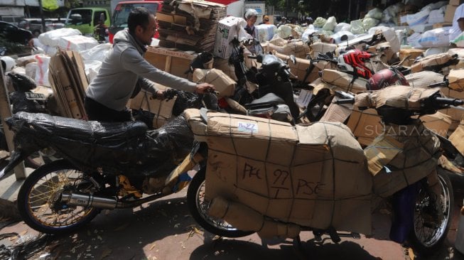 Pekerja merapikan sepeda motor yang akan dikirim di Stasiun Pasar Senen, Jakarta, Rabu (29/5). [Suara.com/Muhaimin A Untung]
