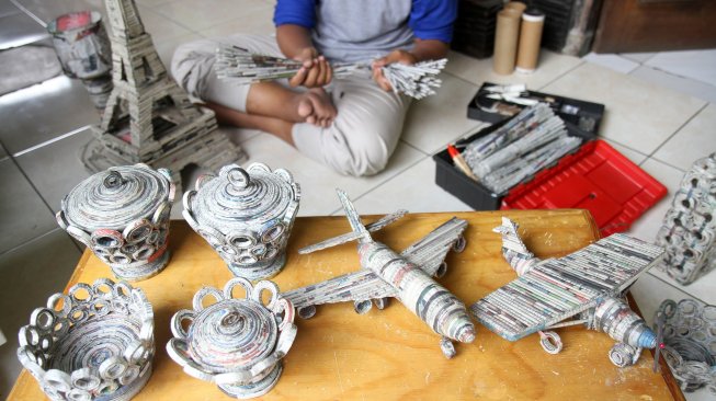 Pengrajin menyelesaikan pembuatan kerajinan tangan berbahan baku limbah kertas koran di Dapur Akasia Art, Jalan Akasia, Pamulang, Tangerang Selatan, Banten, Rabu (29/5). [Suara.com/Arief Hermawan P]