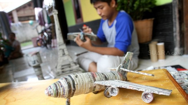 Pengrajin menyelesaikan pembuatan kerajinan tangan berbahan baku limbah kertas koran di Dapur Akasia Art, Jalan Akasia, Pamulang, Tangerang Selatan, Banten, Rabu (29/5). [Suara.com/Arief Hermawan P]