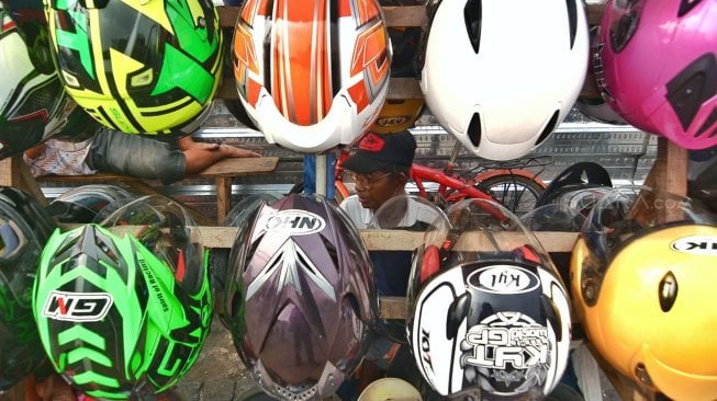 Jajaran helm yang dijual oleh pedagang di Jl Matraman, Jakarta. [Suara.com/Muhaimin A Untung]