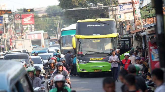 Sejumlah penumpang menunggu Bus Antar Kota Antar Provinsi (AKAP) di terminal bus bayangan di Jalan Raya Bogor, Pal, Depok, Jawa Barat, Jumat (31/5).[Suara.com/Arief Hermawan P]