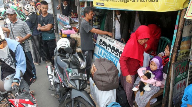 Sejumlah penumpang menunggu Bus Antar Kota Antar Provinsi (AKAP) di terminal bus bayangan di Jalan Raya Bogor, Pal, Depok, Jawa Barat, Jumat (31/5).[Suara.com/Arief Hermawan P]