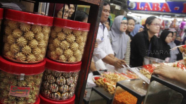 Warga mengantre membeli kue kering di pasar Jatinegara, Jakarta, Sabtu (1/6).[Suara.com/Oke Atmaja]