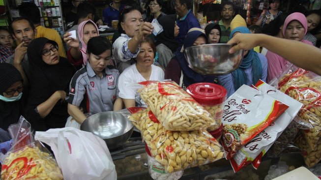 Warga mengantre membeli kue kering di pasar Jatinegara, Jakarta, Sabtu (1/6).[Suara.com/Oke Atmaja]