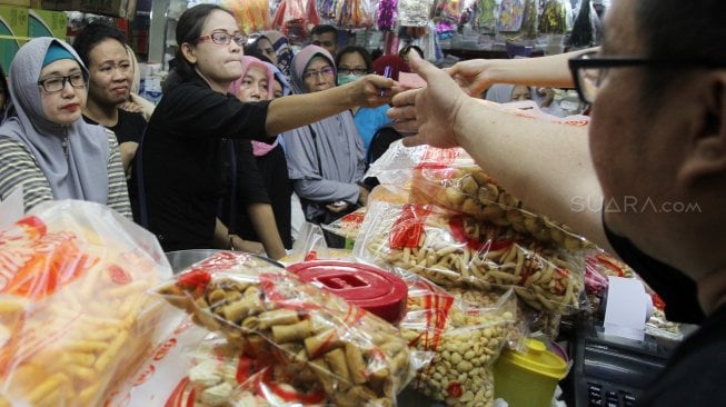 Warga mengantre membeli kue kering di pasar Jatinegara, Jakarta, Sabtu (1/6).[Suara.com/Oke Atmaja]