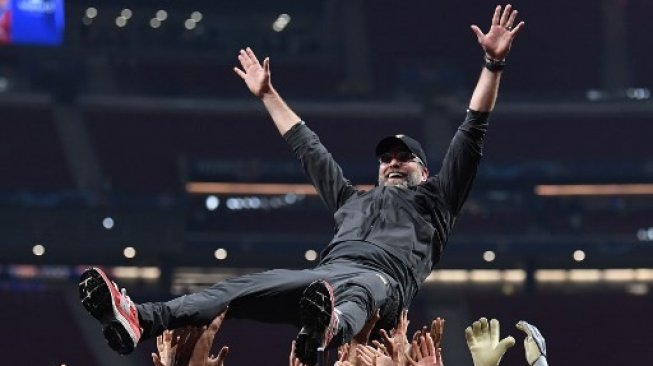Para pemain Liverpool mengangkat Jurgen Klopp ke udara setelah sukses mengalahkan Tottenham Hotspur di final Liga Champions. Paul ELLIS / AFP