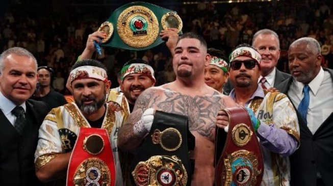 Petinju Amerika Serikat berdarah Meksiko Andy Ruiz Jr (kanan) merayakan kemenangan atas Anthony Joshua dari Inggris dengan kemenangan TKO dalam laga tinju kelas berat kelas berat WBA, WBO, dan IBF di New York, AS. TIMOTHY A. CLARY / AFP