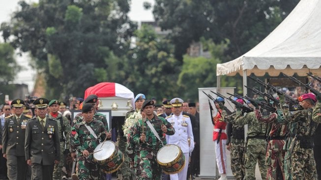 Prajurit TNI melepaskan tembakan ke udara saat prosesi pemakaman istri presiden ke-6 RI Susilo Bambang Yudhoyono (SBY), Ani Yudhoyono di TMP Kalibata, Jakarta, Minggu (2/6). [Suara.com/Muhaimin A Untung]