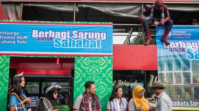 Panitia dari Keluarga Alumni Universitas Gadjah Mada (Kagama) berkostum superhero Spiderman membagikan sarung dan uang fitrah kepada warga pada kegiatan Berbagi Sarung Untuk Sahabat di Balaikota Solo, Jawa Tengah, Senin (3/6). [ANTARA FOTO/Mohammad Ayudha]