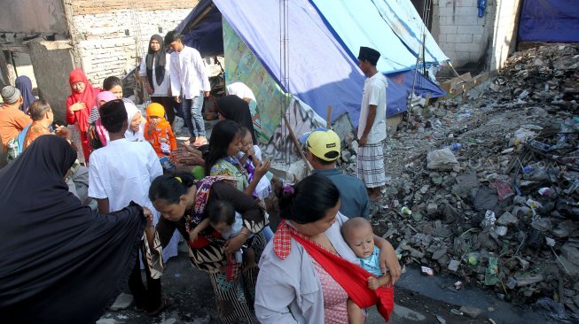 Warga Kampung Bandan beraktifitas di sekitar bangunan sisa kebakaran yang dijadikan pengungsian, Pademangan, Jakarta, Rabu (5/6). [Suara.com/Arief Hermawan P]