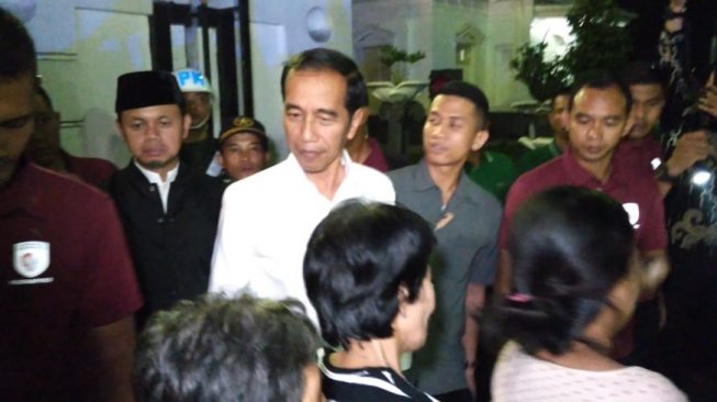 Presiden Joko Widodo (Jokowi) membagikan paket sembako kepada warga di depan Istana Kepresidenan Bogor, Kota Bogor, Jawa Barat. (Suara.com/Rambiga)