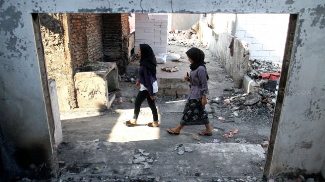 Warga Kampung Bandan beraktifitas di sekitar bangunan sisa kebakaran yang dijadikan pengungsian, Pademangan, Jakarta, Rabu (5/6). [Suara.com/Arief Hermawan P]