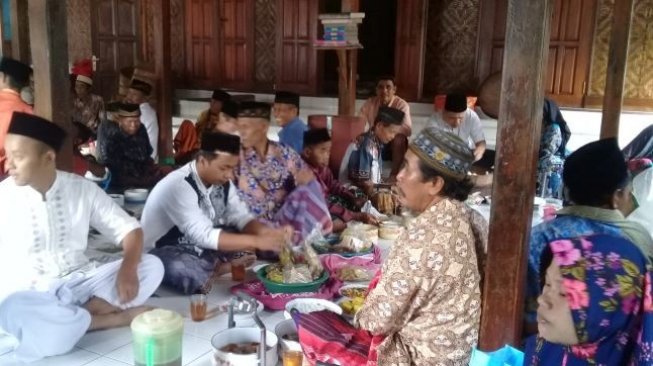 Suasana makan bersama Jamaah Aboge usai Salat Idul Fitri. (Suara.com/Teguh Lumbiria)