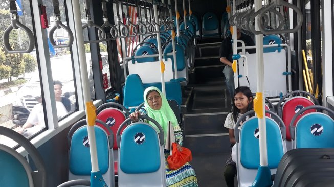 Inah dan cucunya di Transjakarta menikmati layanan gratis [Suara.com/Novian Ardiansyah].